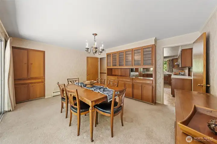 The formal dining room offers generous space for hosting, complete with built-in cabinetry that provides excellent storage for dinnerware, serving pieces, and entertaining essentials. Notice the open pass-through that  makes serving easy while keeping everyone connected.