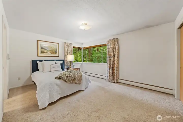 The Primary Suite offers an expansive retreat with plenty of room for a king-size bed, additional seating, or a private reading nook. Large picture windows frame peaceful views of the surrounding greenery, creating a relaxing space to begin and end each day.