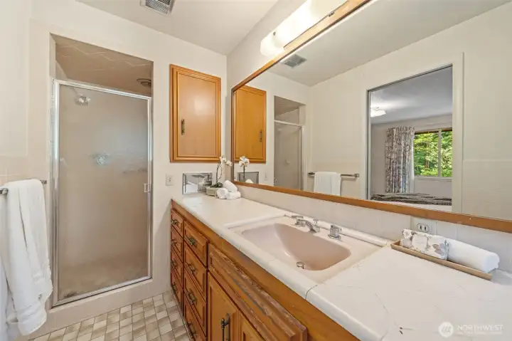 The private en-suite bathroom off the Primary bedroom features an extended vanity with abundant counter space and storage, making busy mornings effortless. A walk-in shower and direct connection to the Primary Suite create a comfortable, well-designed owner's retreat.