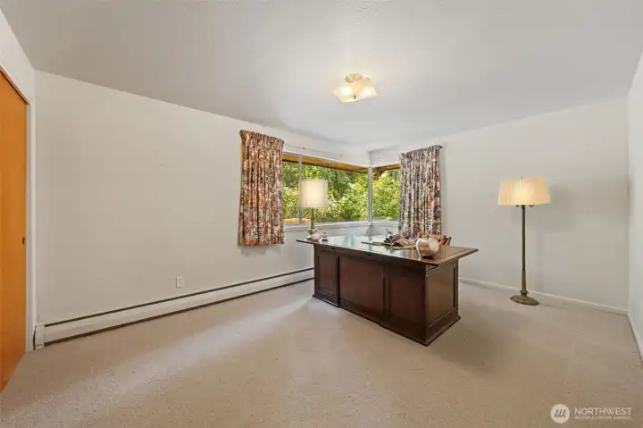 Bedroom Two offers generous space for a bedroom, home office, or guest retreat, with a large picture window that overlooks the private backyard and surrounding greenery. The versatile layout makes it easy to personalize while enjoying peaceful natural views.