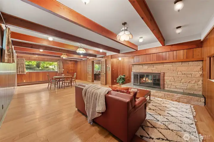 The expansive family room features exposed beam ceiling, a dramatic stone fireplace, and a private exterior entrance that creates exceptional flexibility for multigenerational living or extended guest accommodations. Step outside to a dedicated patio exclusive to this space, providing a true sense of independence while maintaining a connection to the rest of the home.