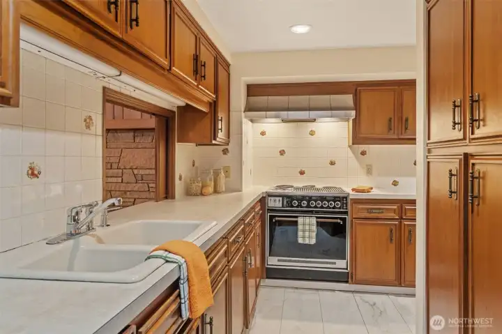 The lower-level kitchen offers abundant cabinetry, generous counter space, and a functional layout that makes meal preparation simple and efficient. A convenient pass-through window connects to the family room, creating an ideal setup for entertaining, multigenerational living, or guest.