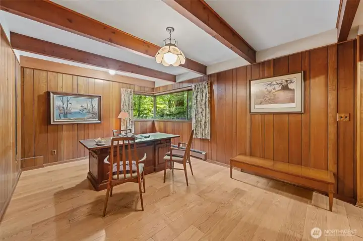 Noted as "Office" on floor plan, this fourth bedroom has its closet right around the corner, off the hall. Notice the exposed wood beams, rich wood paneling, and large corner windows overlooking the private backyard provide a productive and inspiring setting. Conveniently located just off the family room, this flexible space also works beautifully as a bedroom, a creative studio, library, or hobby room while maintaining privacy from the main living areas.