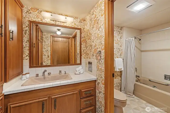 The lower-level full bathroom features a spacious vanity with ample storage, a tub and shower combination, and a functional layout that comfortably serves the family room, office, and nearby living spaces. Its convenient location enhances the lower level's flexibility, making it an excellent complement to multigenerational living, extended guest stays, or a private home office suite.