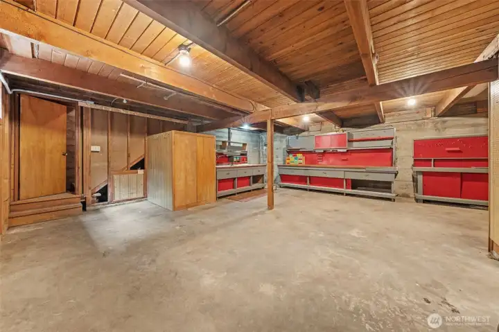 The spacious lower-level workshop provides plenty of room for woodworking, hobbies, projects, or extra storage with built-in workbenches already in place. Convenient access from both the garage and the lower-level living area makes it easy to move between projects while keeping this dedicated workspace separate from the rest of the home.