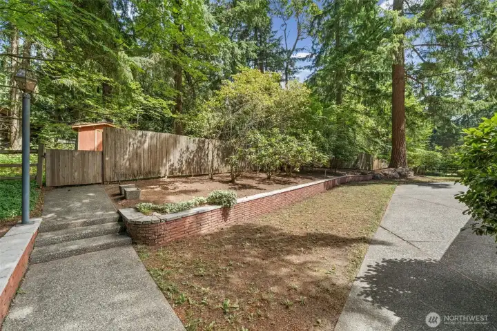 A gated entrance at the back of the yard provides direct access to the pasture beyond, adding to the property's unique setting. Mature landscaping and open green surroundings create a private and tranquil outdoor retreat.