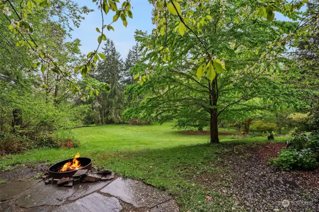 Fire pit patio overlooking green pasture. The parcel is 4.98 acres with 3.96 acres in the King County PBRS Open Space Program which affords privacy and reduced taxes.