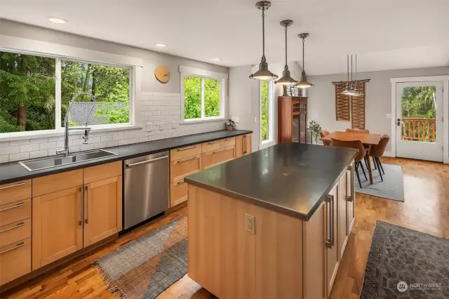 Large island with stainless style countertop and ample lighting. Tall ceilings.