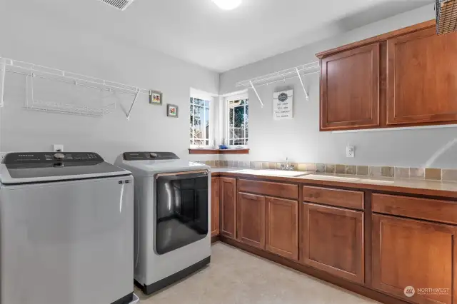 Laundry room with folding area and sink. New washer & dryer stay.