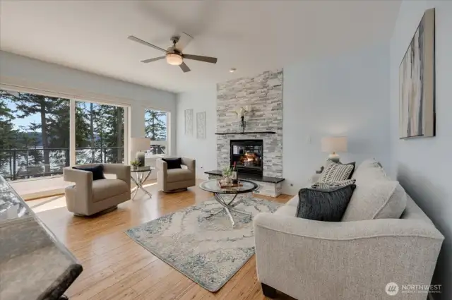 Main floor living room with large windows, slider to deck and gas fireplace