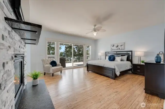Primary suite with slider to deck, gas fireplace, luxurious full bath, custom walk-in closet, and private den/office