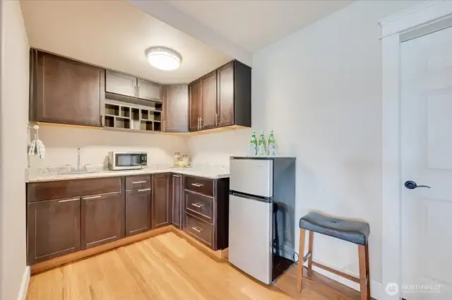 LL kitchenette/wet bar. Fridge & microwave convey. 2nd laundry and large storage room behind the door.