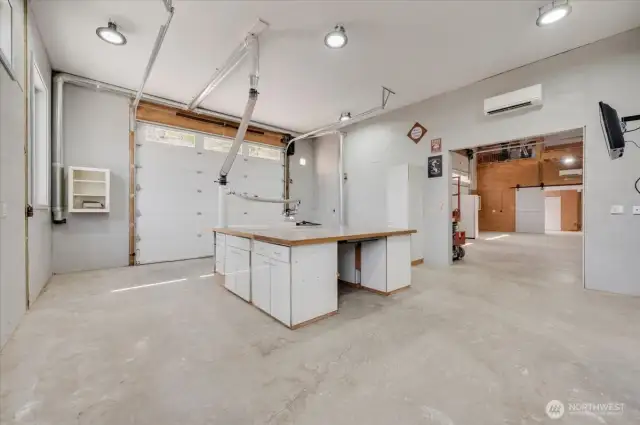 Wood shop with vacuum system, large workbench/runout table with storage, power and table saw