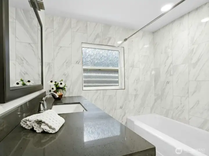 Quartz countertop vanity, Large bathtub with shower, medicine cabinet above the toilet