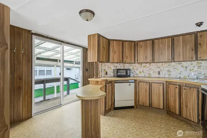 Functional kitchen layout with built-in peninsula, generous storage, and sliding door access to the covered patio.