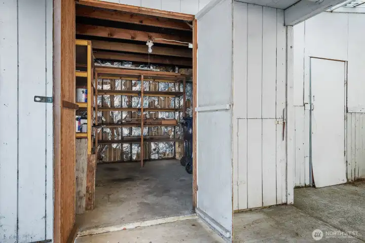 Workshop or storage area with built-in shelving and space for projects or extra storage needs.