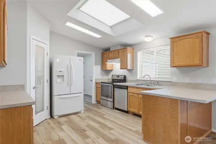 Kitchen is nicely laid out with plenty of counter and cabinet space.  Walk in pantry. Door leads to laundry room and out to good sized two car garage.