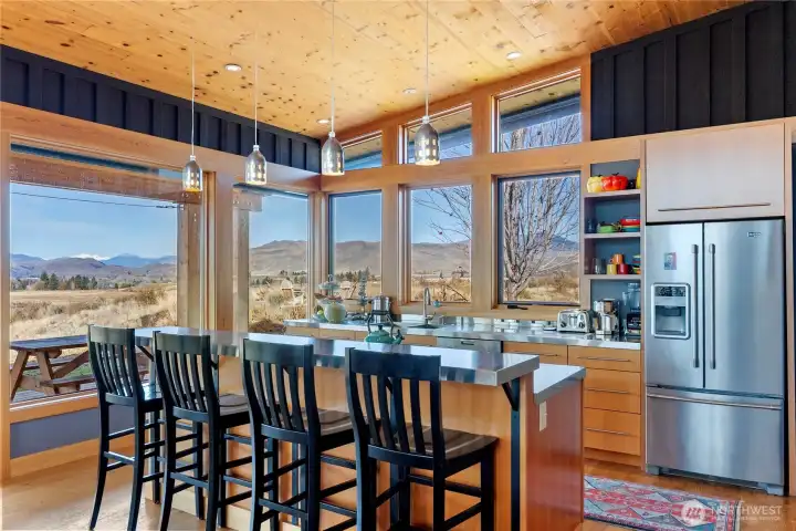 The cook's kitchen has a long eating bar with views to the expansive landscape to the north.