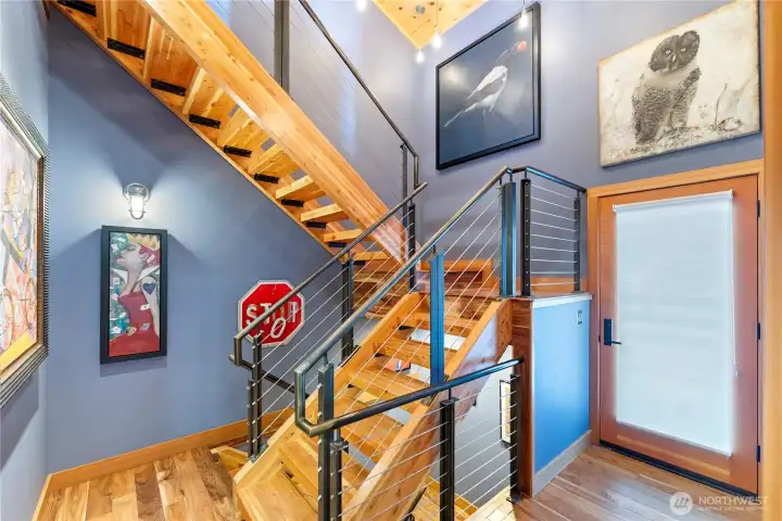 A dramatic wood and steel stair leads down to the wine cellar or up to the apartment.