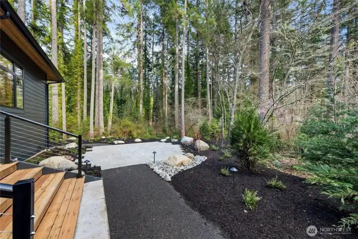 paver patio off the covered deck and into the woods of this 1 acre property