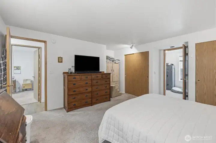 Primary bedroom. Picture taken from the bathroom door. Left door leads to hall to the house and right open door is large walk in closet