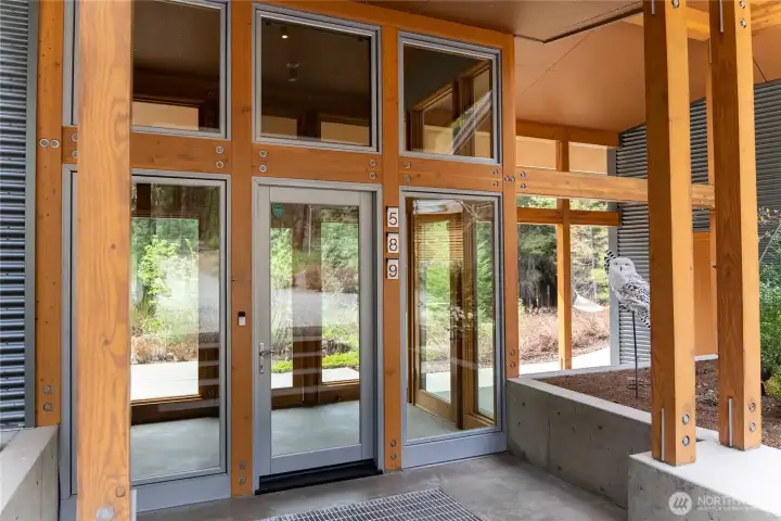 The main entry with walk-off grate leads to an atrium-style mudroom with heated floor.
