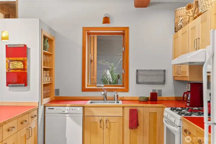A kitchen window looks out on the garden entry.