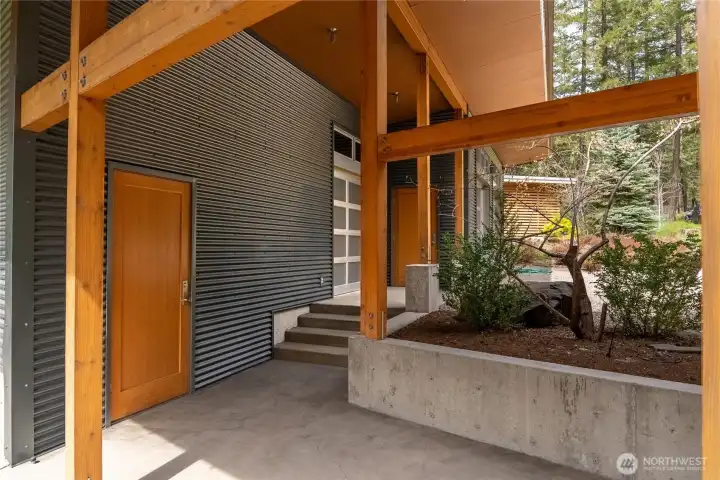 The covered walkway leads past the large storage room, shop with roll-up door, and on to the 2-car garage.