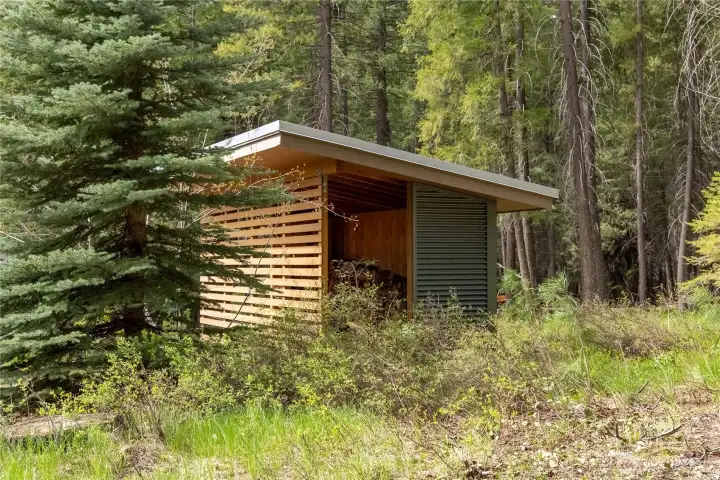 A separate woodshed provides additional storage.