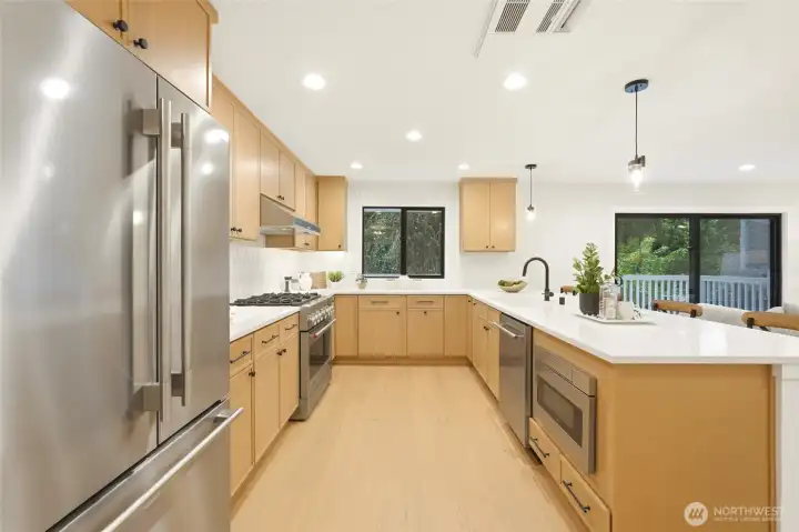 Beautifully renovated kitchen featuring white oak cabinetry, stainless appliances, and abundant storage.
