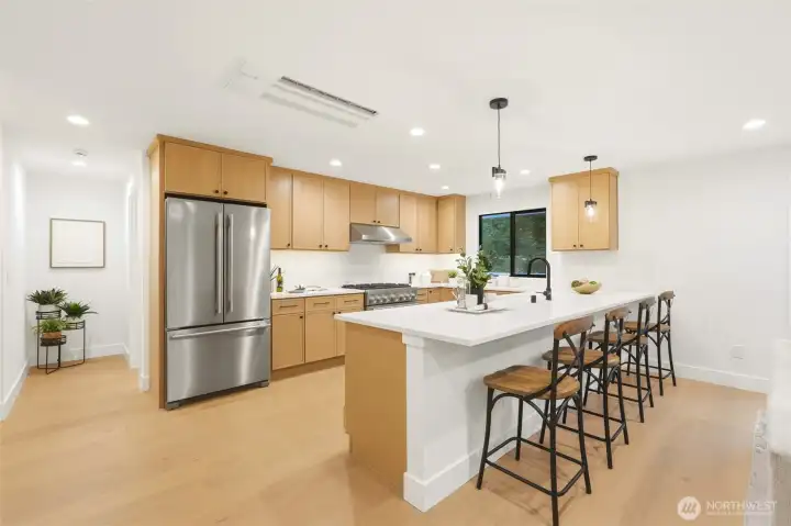 Large island peninsula anchors the kitchen and offers ideal space for casual dining and gathering.