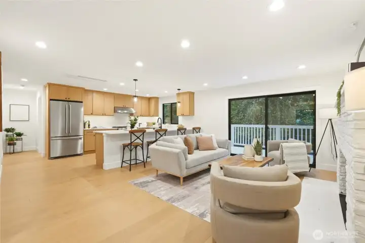 Spacious living area with fireplace, fresh flooring, and seamless connection to the kitchen.