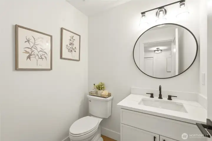 Stylish powder bath with updated vanity, lighting, fixtures, and fresh modern finishes.