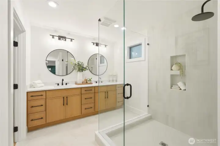 NEW primary bath with dual vanity, glass shower, and warm designer finishes.