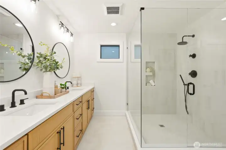 Beautiful 3/4 primary bath featuring new tile, modern fixtures, and a walk-in shower.