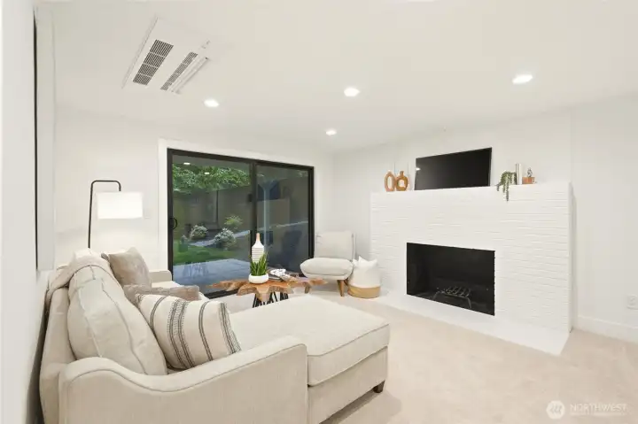 Comfortable lower-level living area with updated finishes, fireplace, and room to lounge, work, or play.