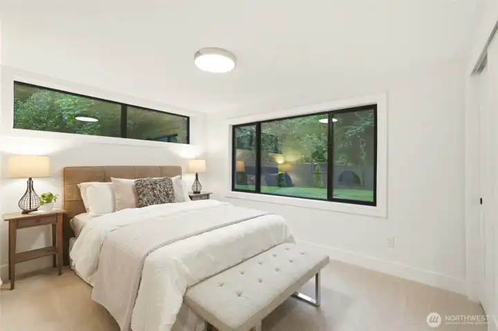 Lower-level bedroom with fresh flooring, natural light, and a clean modern feel.