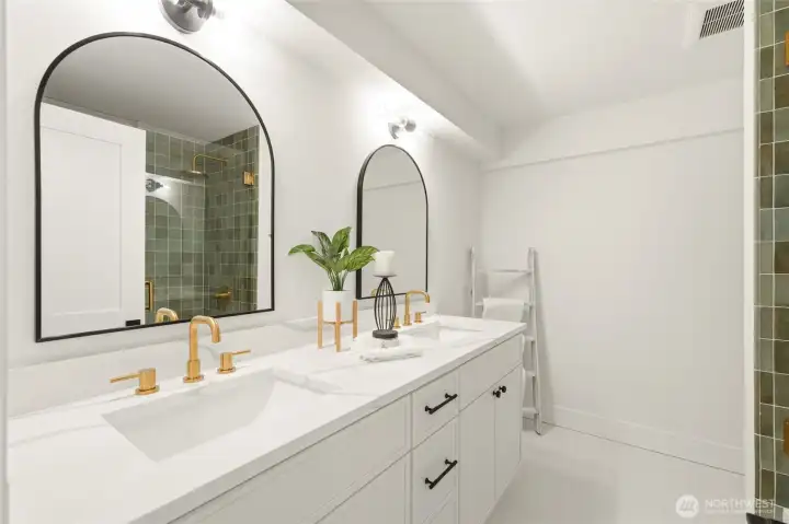 Renovated full bath with dual vanity, updated lighting, modern fixtures, and timeless finishes.