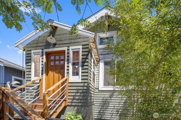 The home sits high off the street, with high fences and lush landscaping.