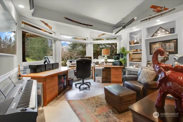 Left of the Entry you'll find this pectacular home office/Music Room with upper mood lighting can down lighting, and a custom desk built into the 15 Ft. Bay Window with view.