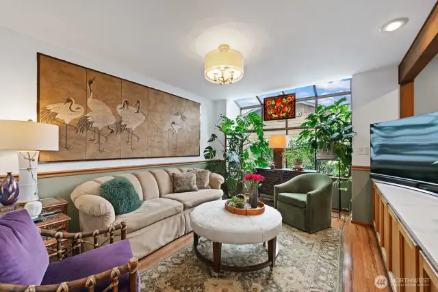 The family room (shown here as a media room) makes for comfy home theater setting. There is a row of under-cabinet storage and also a garden-bay window to enhance the warm light of this room.