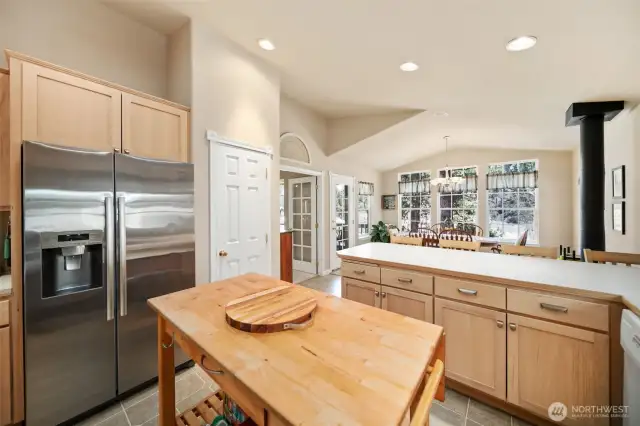 Kitchen looking towards eating bar & dining room with woodstove (pantry to the left).
