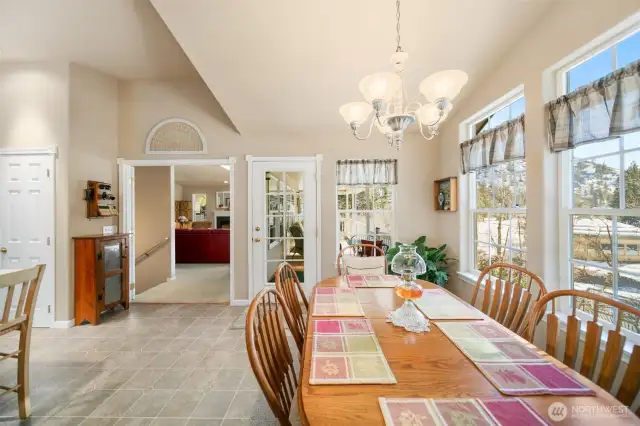 Dining room & kitchen area looking towards the living room (stairway to downstairs to the left) and door to the deck is straight ahead. Glass French doors can be closed to separate the spaces.