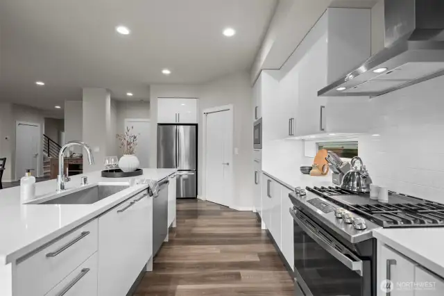 The builder did not cut corners: piano finish soft close cabinetry w/ pull-down shelving, cabinet organizers, trash/recycle bins, under cabinet lighting etc.