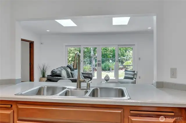 View from the kitchen to the family room through the new double gliding doors by Renewal by Anderson to the private deck & back yard. Perfect for entertaining & relaxing.