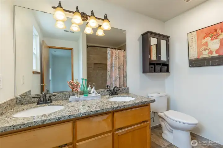 Primary bathroom with dual sinks, beautifully-tiled shower.