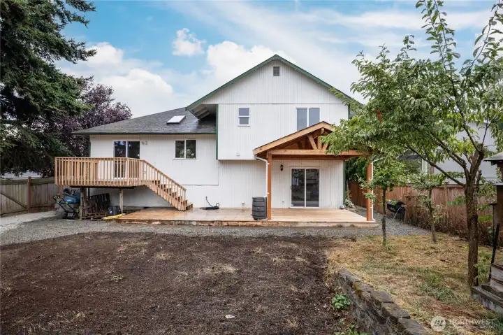 Fully-fenced back yard features an extensive deck
