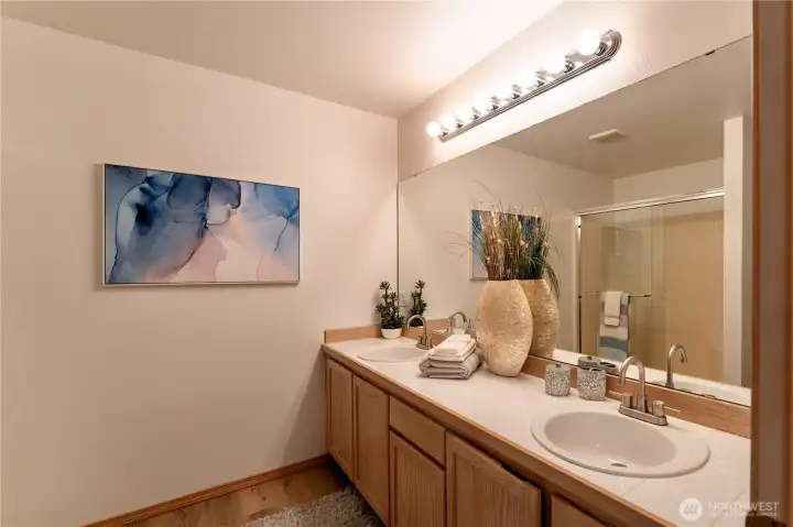 En suite primary bathroom with dual sinks .