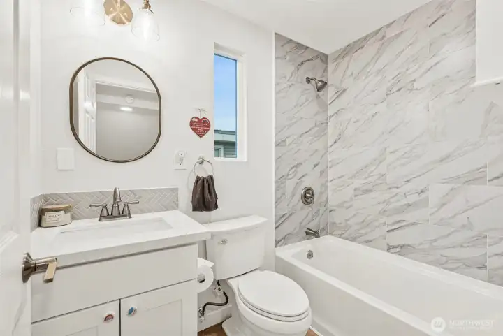 Upstairs full bath with stylish cabinets, lighting and quartz countertops.