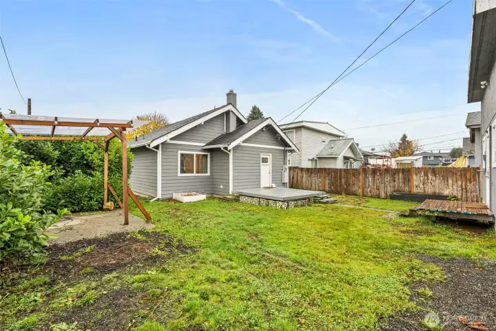 View of back of house into backyard, with space for a hot tub, lots of room to entertain/play.